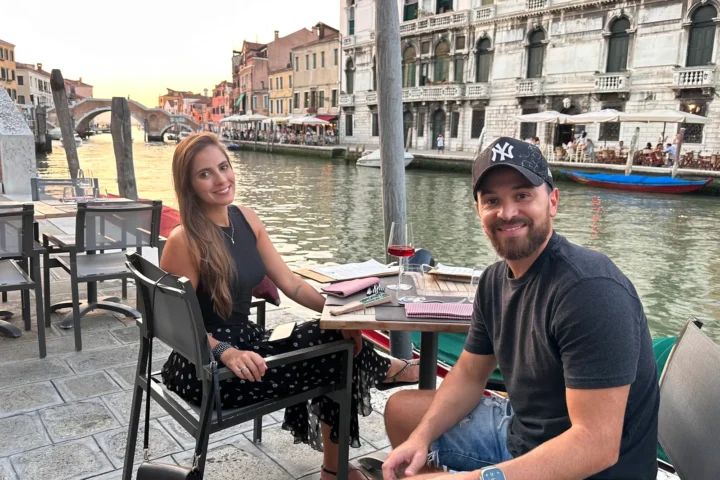 Casal durante uma viagem em Veneza, à beira de um canal