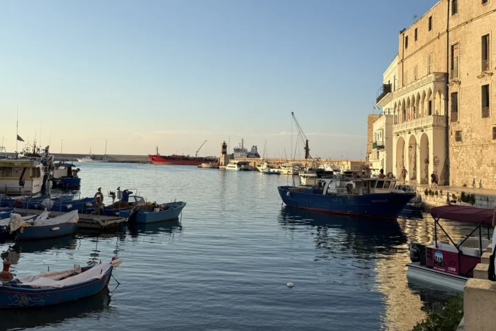 Porto Antico de Monopoli com barcos de pesca e construções históricas ao entardecer