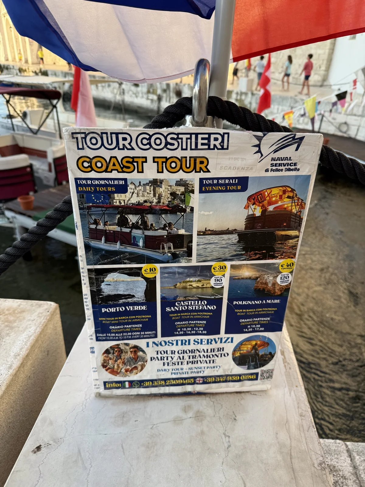 Placa com opções de passeios de barco anunciados no porto de Monopoli