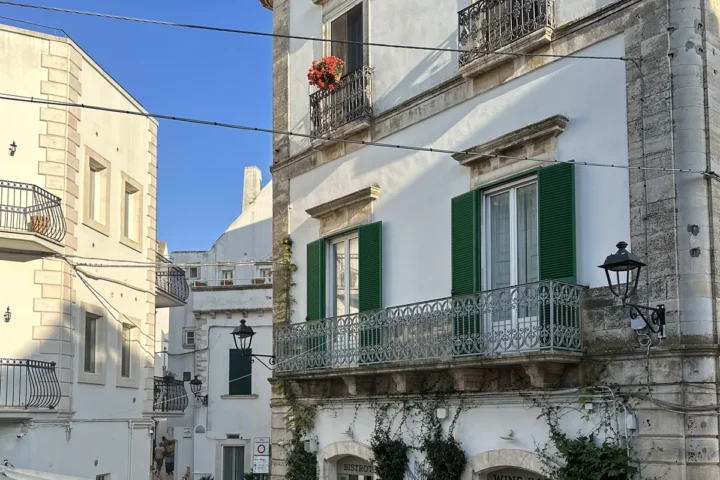 Fachada branca com janelas verdes no centro histórico de Locorotondo, na Puglia
