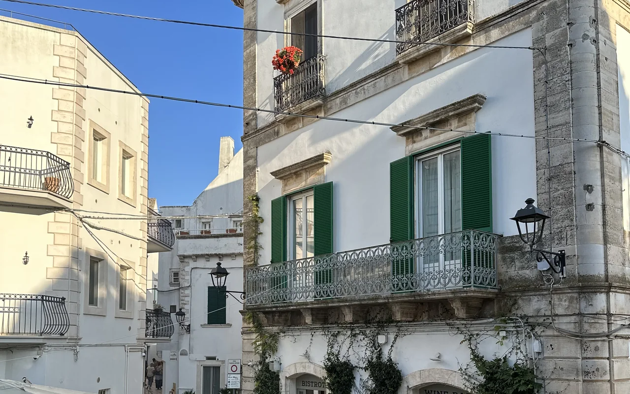 Fachada branca com janelas verdes no centro histórico de Locorotondo, na Puglia
