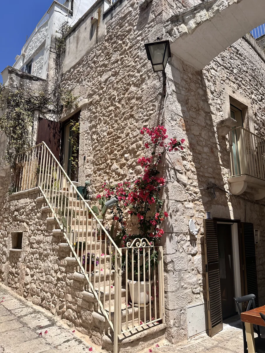 Escadaria de pedra e flores em uma rua de Cisternino, na Puglia